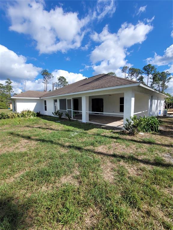 The exterior of a white house features a covered screened-in patio and a shingled roof — 1402 JAKWAY ROAD, NORTH PORT, FL