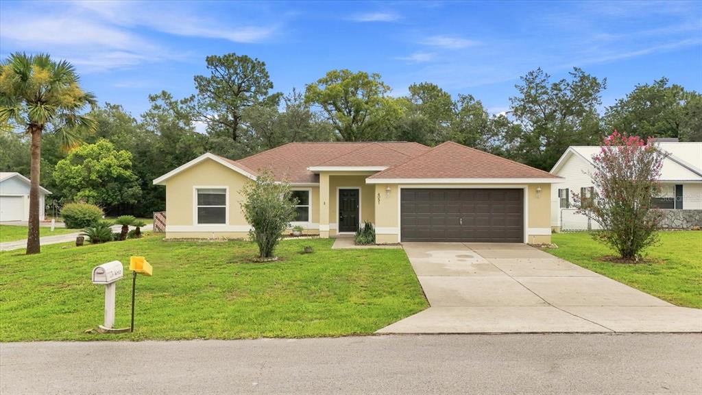 A single-story house with a tan exterior, brown roof, and a two-car garage — 4051 S WINDING OAKS DRIVE, HOMOSASSA, FL