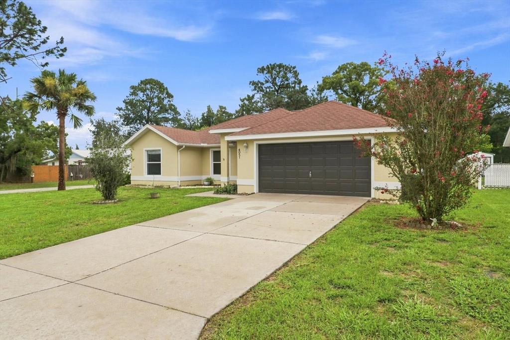 A single-story house with a yellow exterior, a brown roof, and a two-car garage — 4051 S WINDING OAKS DRIVE, HOMOSASSA, FL