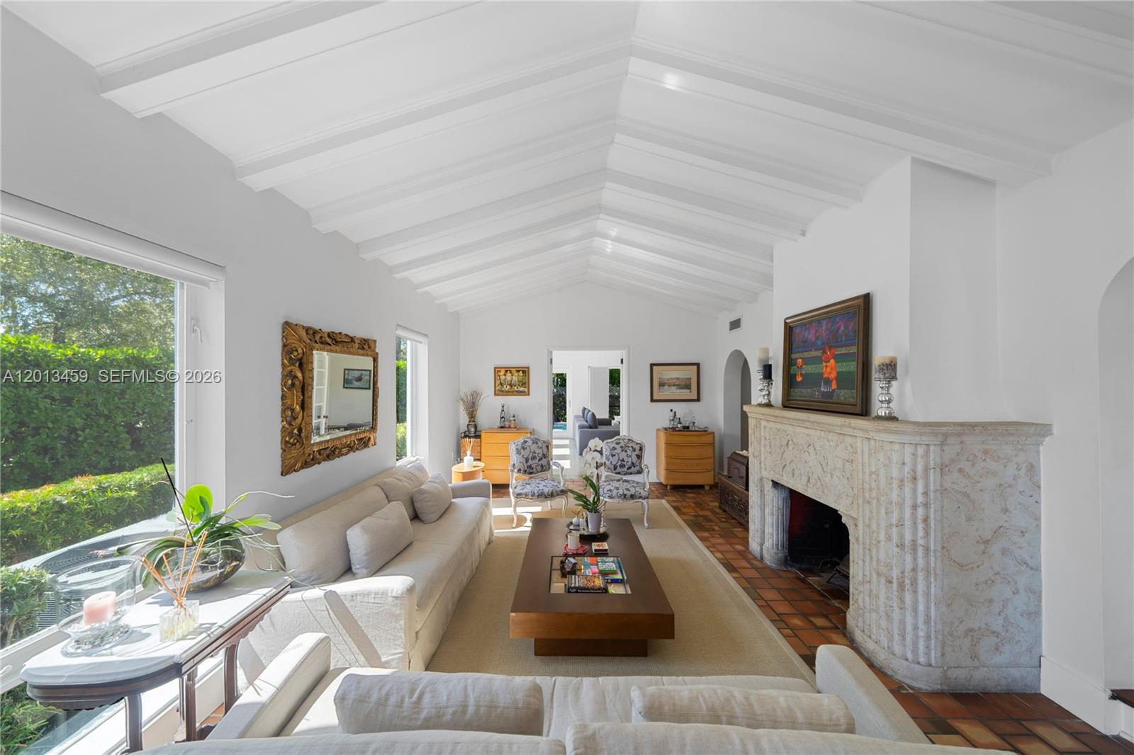A living room features a vaulted beamed ceiling, a stone fireplace, and terracotta tile flooring — 1281 S Venetian Way, Miami FL 33139, MIAMI, FL