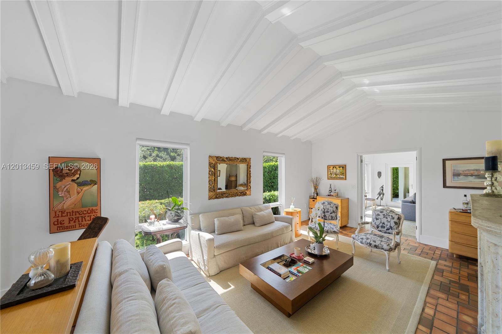 A living room features a vaulted beamed ceiling, terracotta tile floors, and neutral-toned furniture — 1281 S Venetian Way, Miami FL 33139, MIAMI, FL