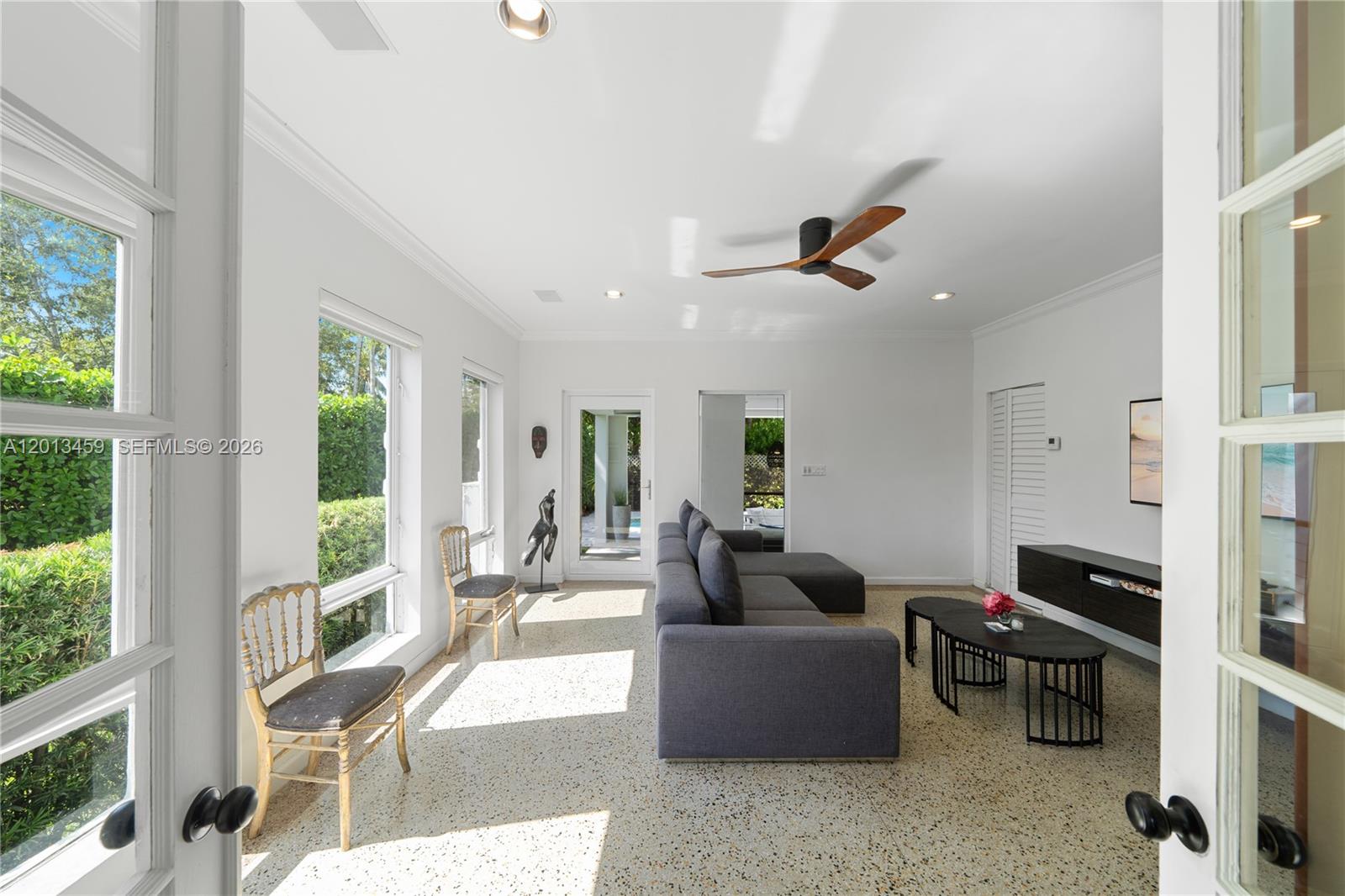 A bright living room features a gray sectional sofa, terrazzo flooring, and large windows — 1281 S Venetian Way, Miami FL 33139, MIAMI, FL