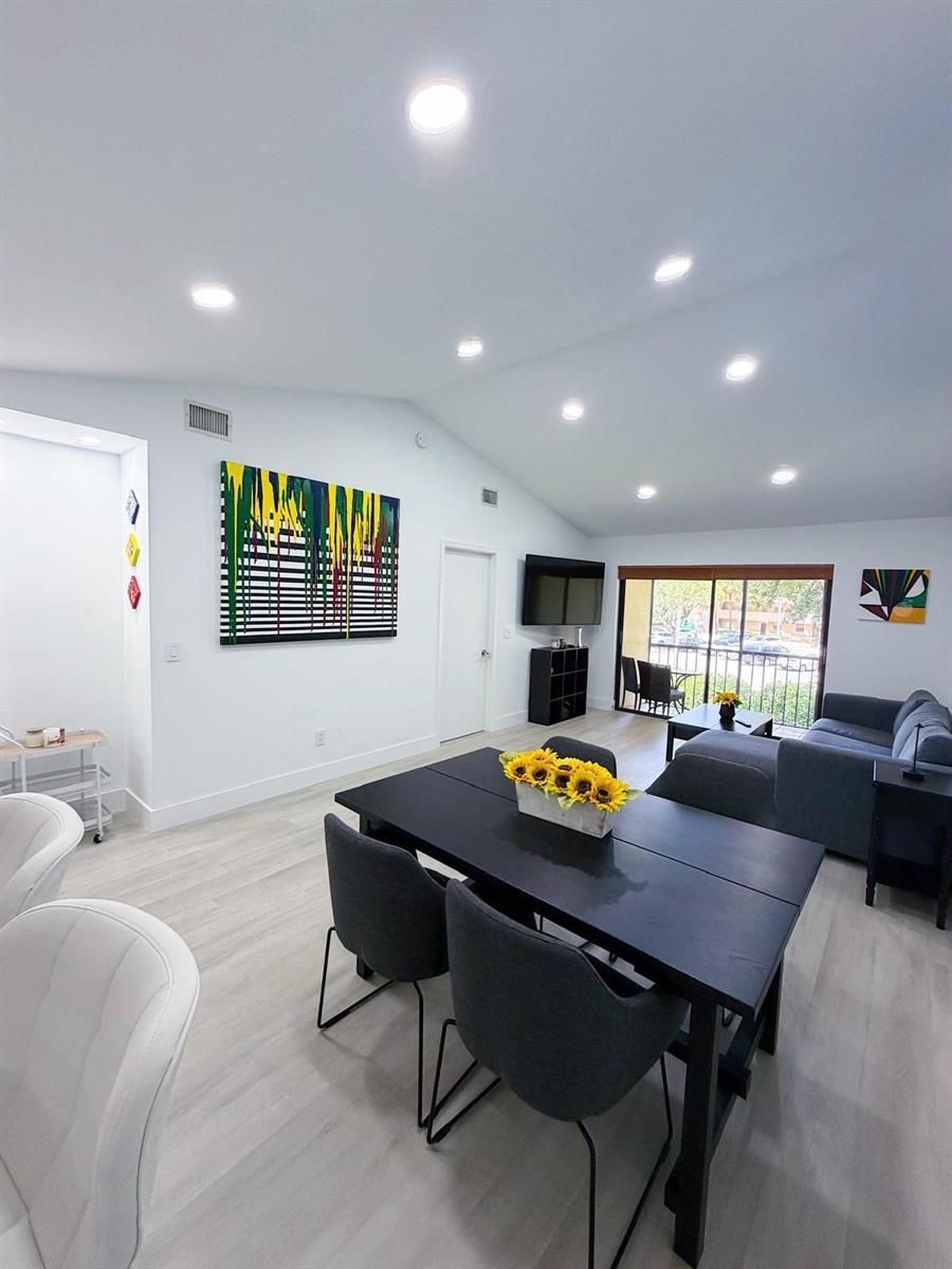 A living and dining area features light wood floors, recessed lighting, and modern furniture — 351 Club Circle # 208, Boca Raton FL 33487, BOCA RATON, FL