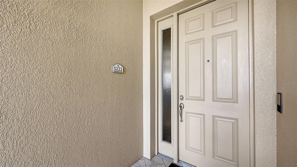 A beige front door with a sidelight and house number 5222 on the wall — 5222 MANORWOOD DRIVE UNIT 4A, SARASOTA, FL