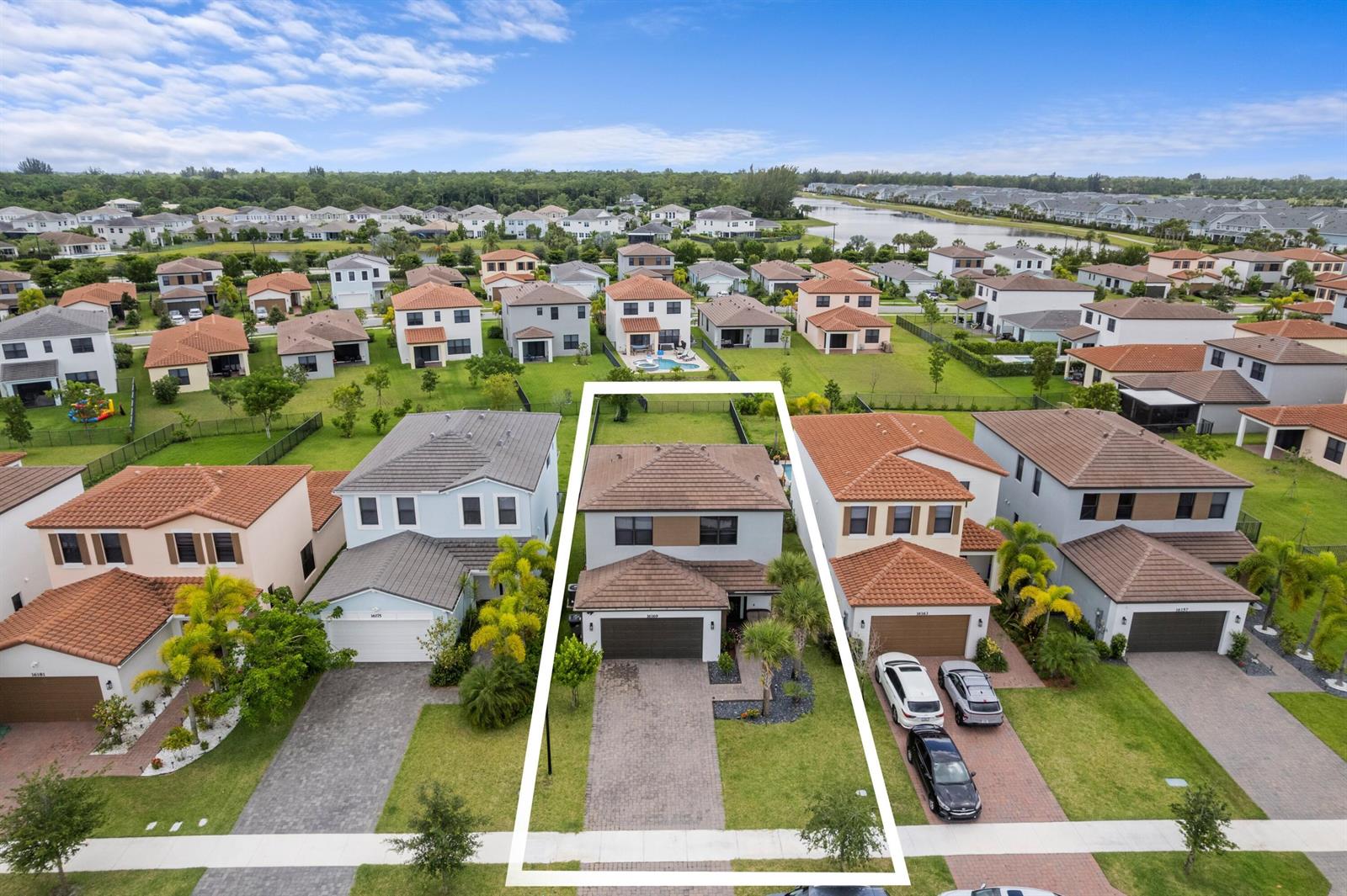 An aerial view shows a two-story suburban house with a tiled roof and paved driveway — 16169 Sea Turtle Place, Westlake FL 33470, WESTLAKE, FL