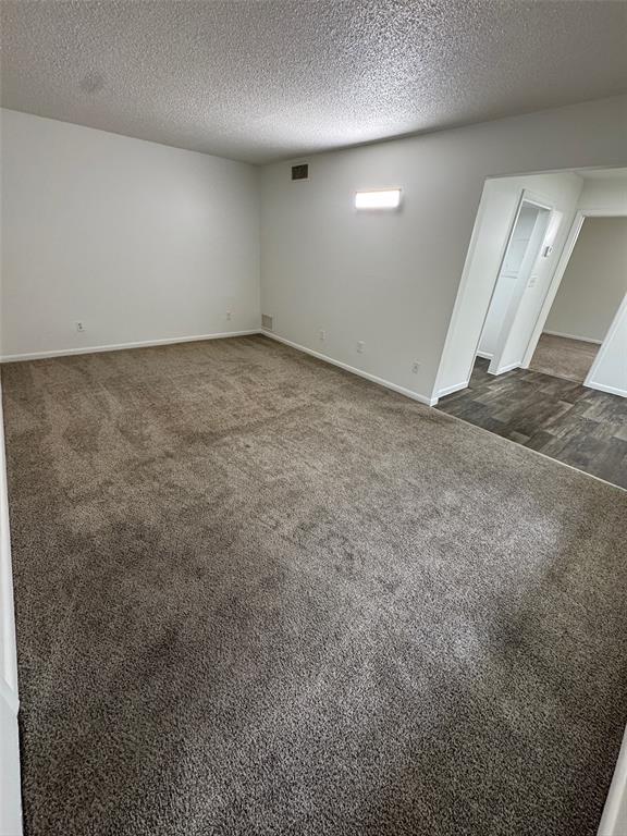 An empty room features gray carpeting, white walls, and a doorway leading to another area — 1745-1745 NE 2ND STREET UNIT 3, OCALA, FL