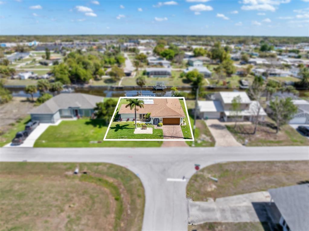 An aerial view shows a single-story house with a tan roof and a front lawn — 2220 BROAD RANCH DRIVE, PORT CHARLOTTE, FL