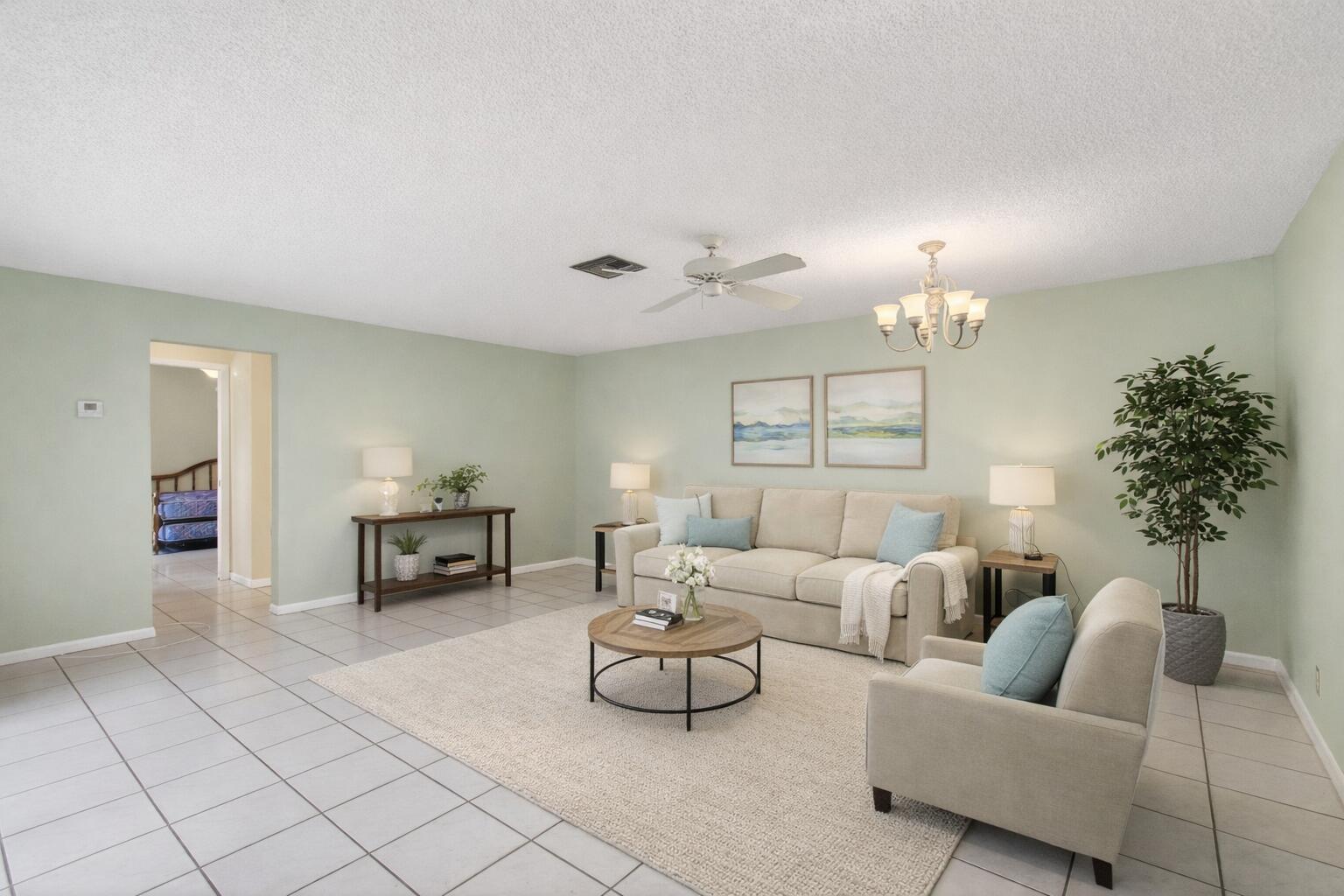 A living room features light green walls, tile flooring, a beige sofa, and a round table — 801 NW 30th Avenue # C, Delray Beach FL 33445, DELRAY BEACH, FL