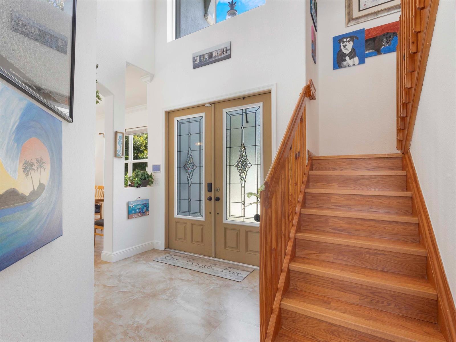 An entryway features a double front door, a wooden staircase, and tile flooring — 6025 Indian Forest Circle, Lake Worth FL 33463, LAKE WORTH, FL