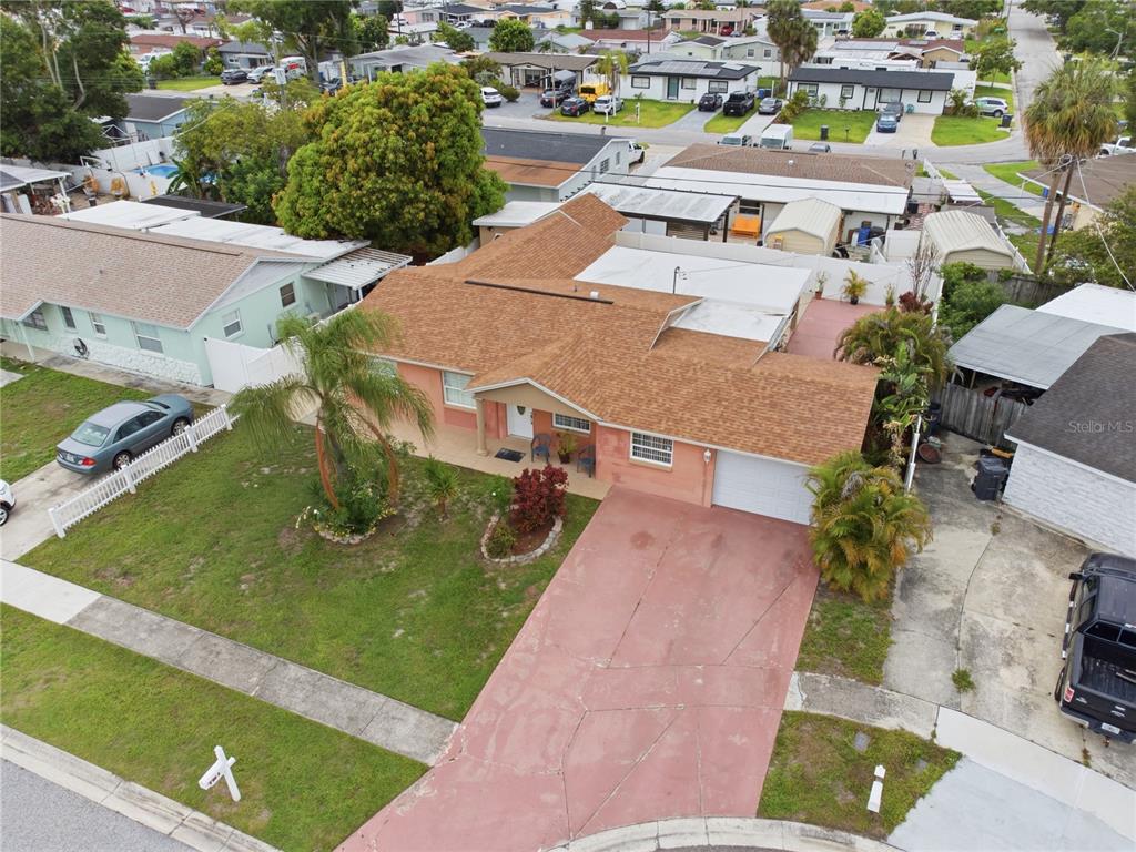 An aerial view shows a single-story house with a brown roof and a red driveway — 4914 HOLIDAY DRIVE, TAMPA, FL