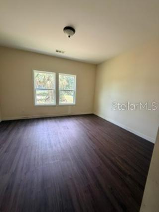 An empty bedroom features light-colored walls, a ceiling light fixture, and dark wood-look flooring — 1835 SPRINGHEAD DRIVE, DELTONA, FL