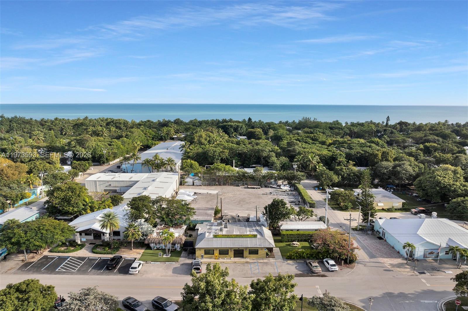 An aerial view shows a commercial building with a parking lot surrounded by lush trees — 105 PALM AVE., Islamorada FL 33036, ISLAMORADA, FL