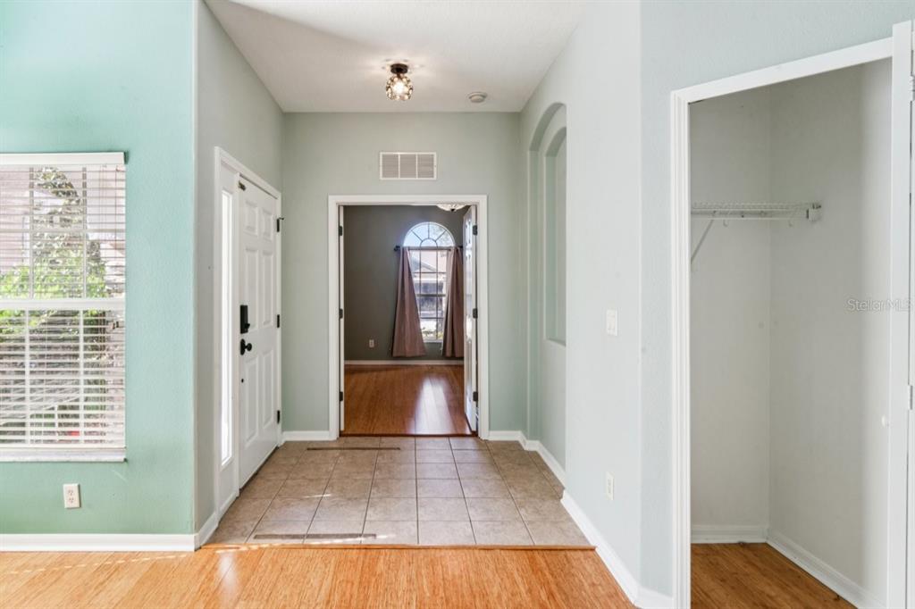 An entryway features tile flooring, a white front door, a coat closet, and an arched doorway — 9314 CREEDMOOR LANE, NEW PORT RICHEY, FL