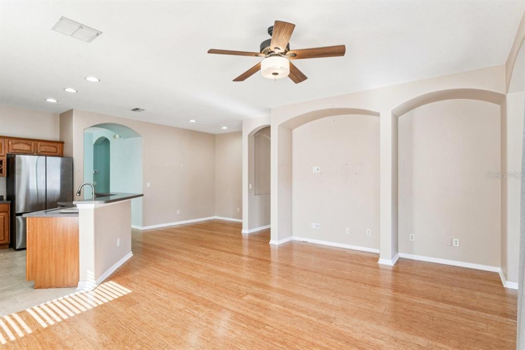 A living room features hardwood floors, a built-in media niche, and a sliding glass door — 9314 CREEDMOOR LANE, NEW PORT RICHEY, FL