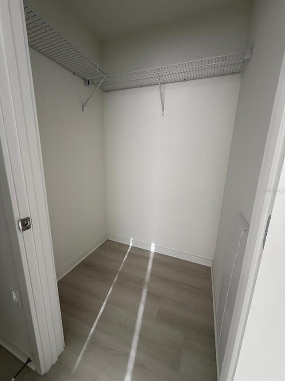 A walk-in closet with light wood-look flooring and white wire shelving — 5579 PGA BLVD UNIT 524, ORLANDO, FL