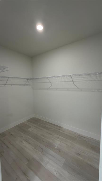 A walk-in closet with white walls, light wood-look flooring, and wire shelving — 2693 JEANNIN DRIVE, NORTH PORT, FL