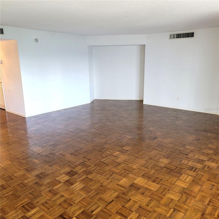 An empty room features white walls, a recessed alcove, and dark parquet wood flooring — 435 S GULFSTREAM AVENUE UNIT 605, SARASOTA, FL