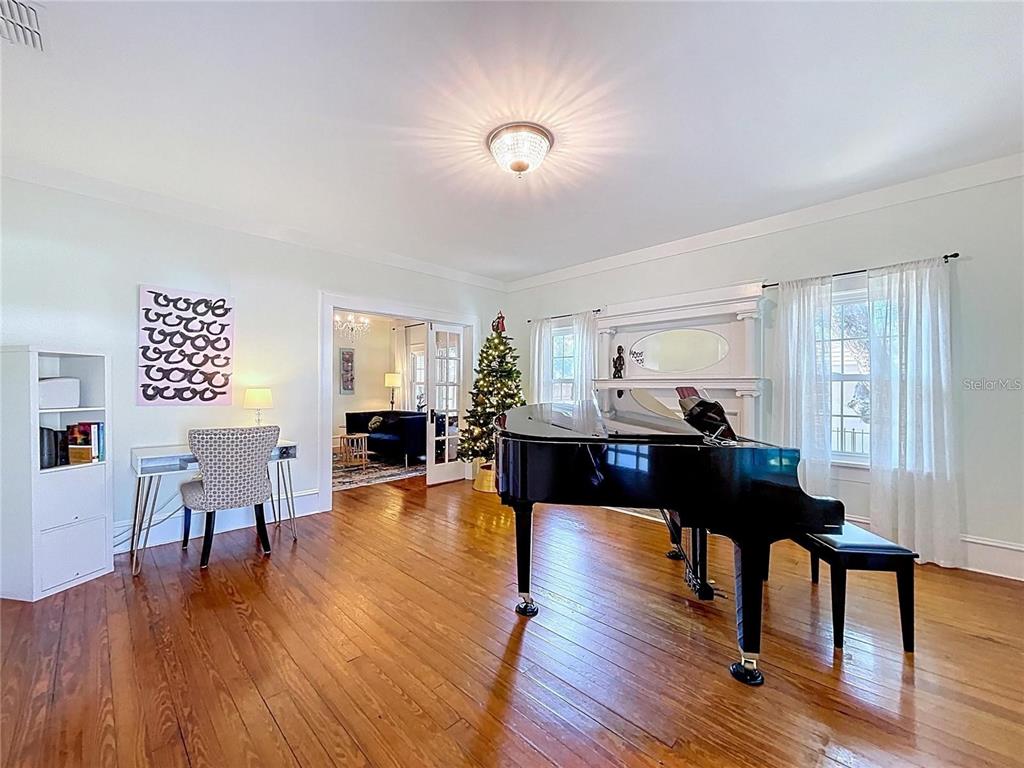 A living room features a grand piano, hardwood floors, a desk, and a Christmas tree — 901 W BAKER STREET, PLANT CITY, FL