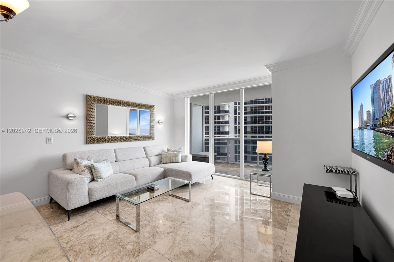 A living room features a light gray sectional sofa, glass coffee table, and marble flooring — 1830 S OCEAN DR # 3310, Hallandale Beach FL 33009, HALLANDALE BEACH, FL