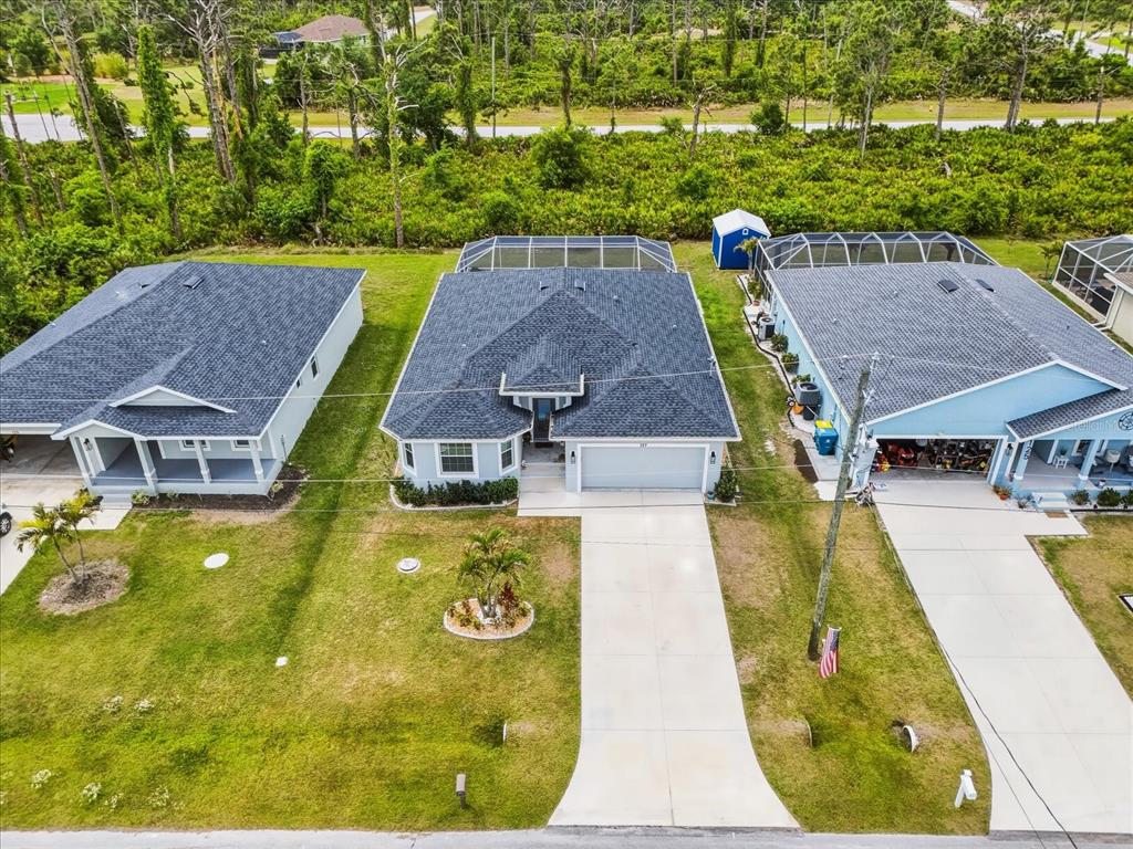 An aerial view shows three suburban houses with driveways, lawns, and screened-in back patios — 127 GLADES DRIVE, ROTONDA WEST, FL