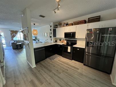 A kitchen with dark lower cabinets, white upper cabinets, and light wood-look flooring — 12326 BERKELEY SQUARE DRIVE, TAMPA, FL