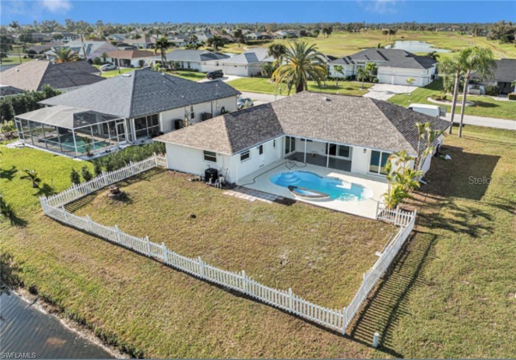 An aerial view shows a house with a fenced backyard, swimming pool, and patio — 257 BUNKER ROAD, ROTONDA WEST, FL