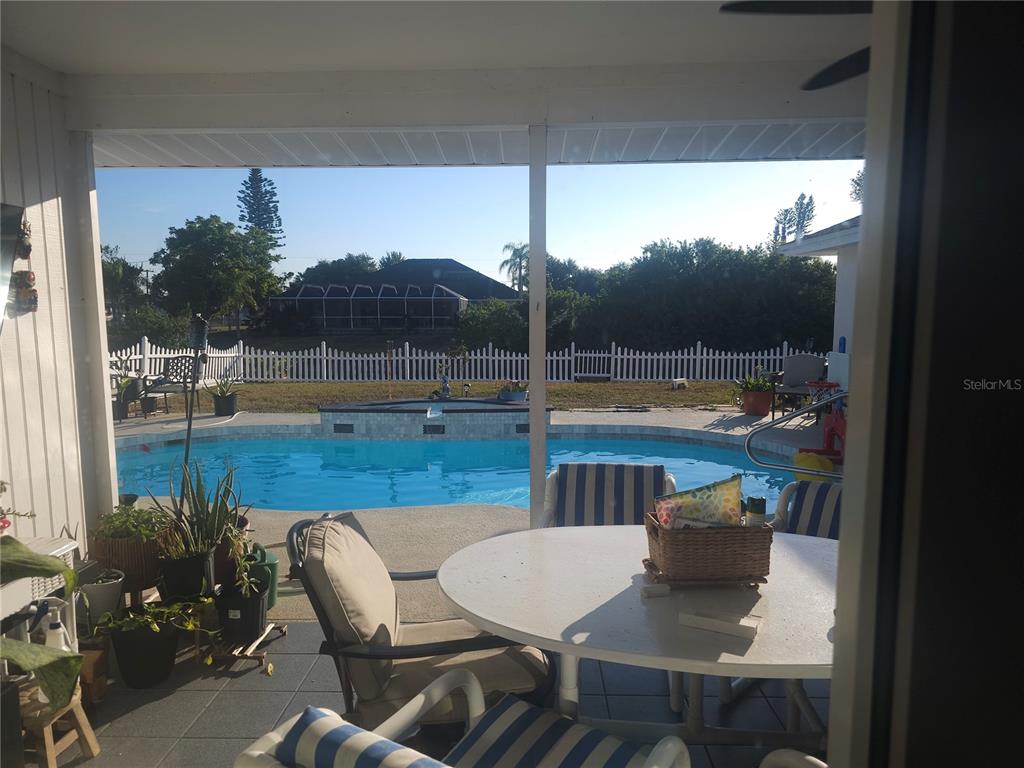 A covered patio overlooks a swimming pool and a fenced backyard — 257 BUNKER ROAD, ROTONDA WEST, FL