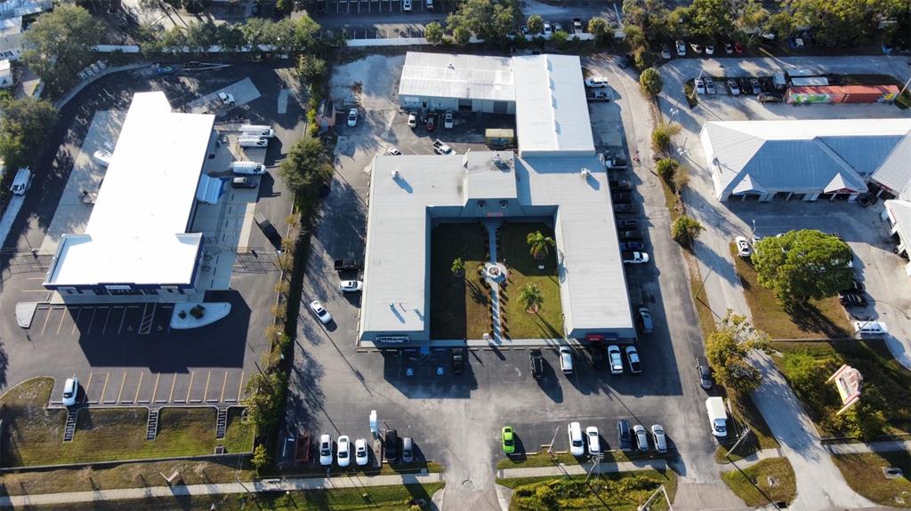 An aerial view shows a U-shaped commercial building with a central courtyard and parking lots — 37548 US HWY 19 N, PALM HARBOR, FL