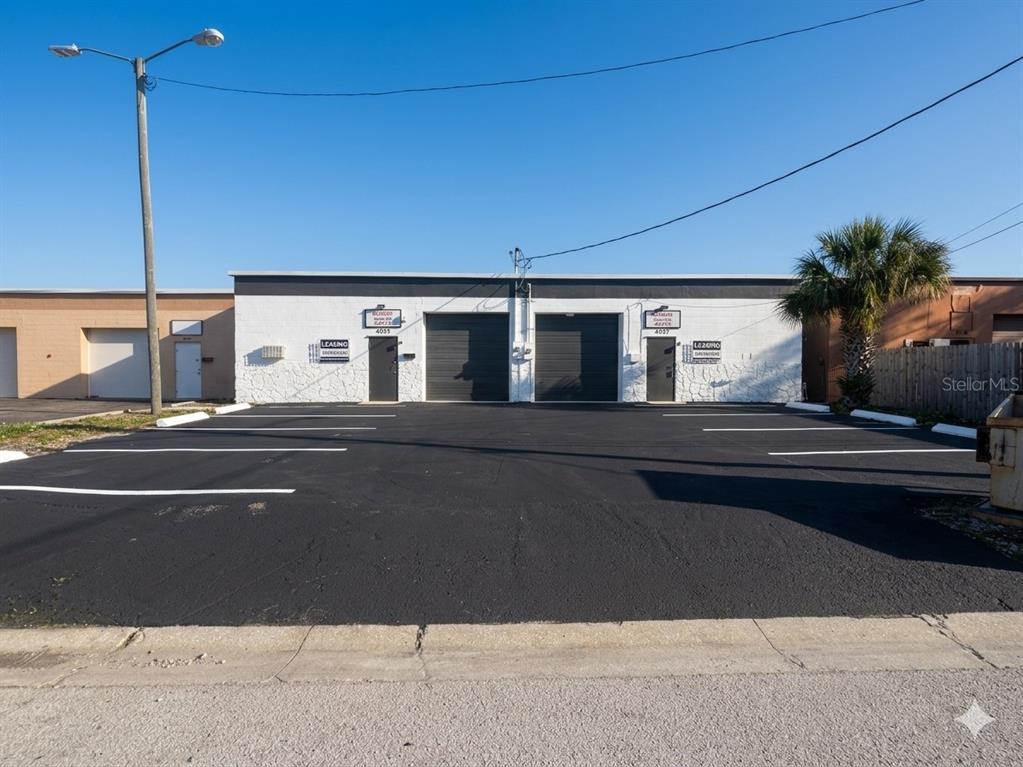 A single-story commercial building with two garage doors and a paved parking lot — 4055 7TH TERRACE, ST PETERSBURG, FL