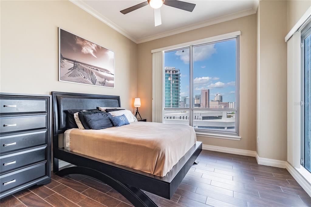 A bedroom with a black bed frame, a tall dresser, and a city view window — 449 S 12TH STREET UNIT 1406, TAMPA, FL