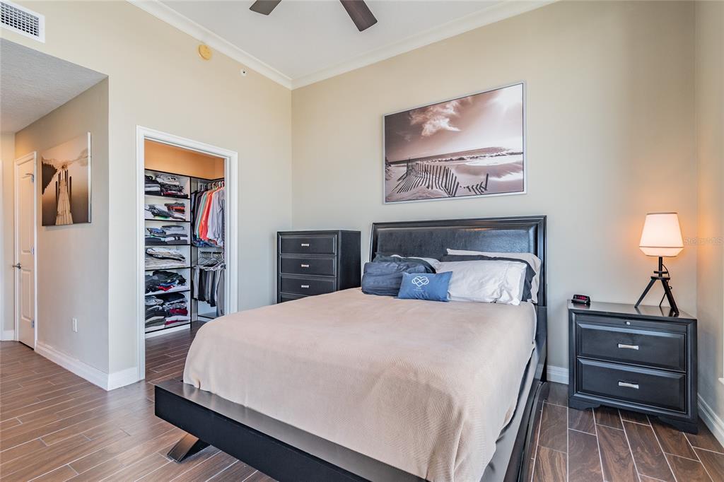 A bedroom features a black bed frame, matching nightstand, dresser, and a walk-in closet — 449 S 12TH STREET UNIT 1406, TAMPA, FL