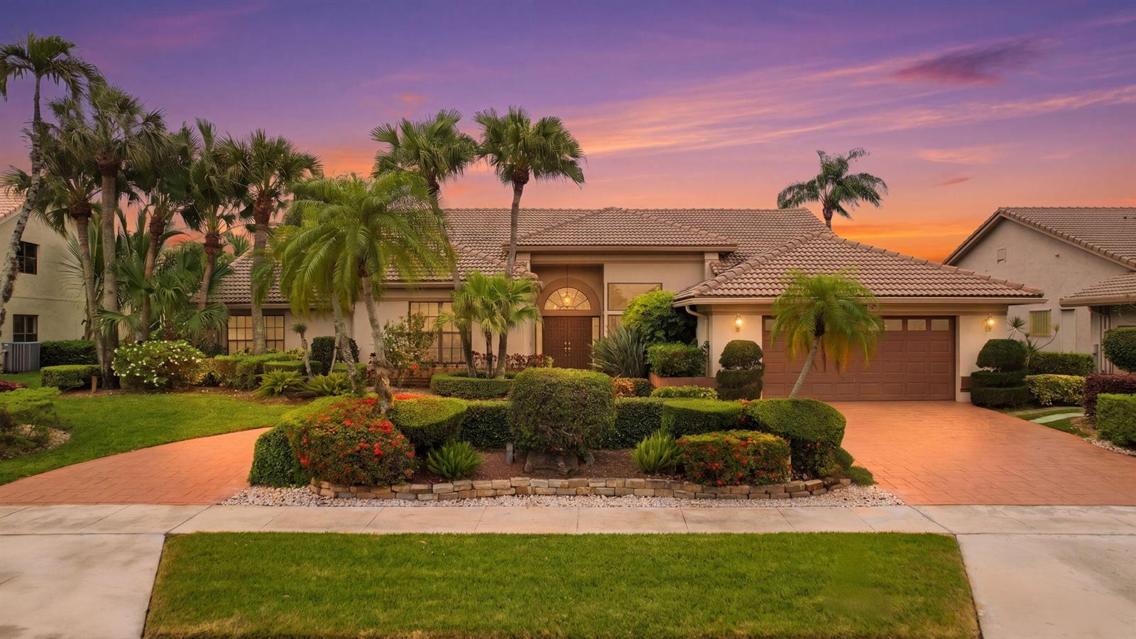 A single-story house with a tiled roof, palm trees, and a paved driveway at sunset — 10330 Silver Lake Drive, Boca Raton FL 33428, BOCA RATON, FL