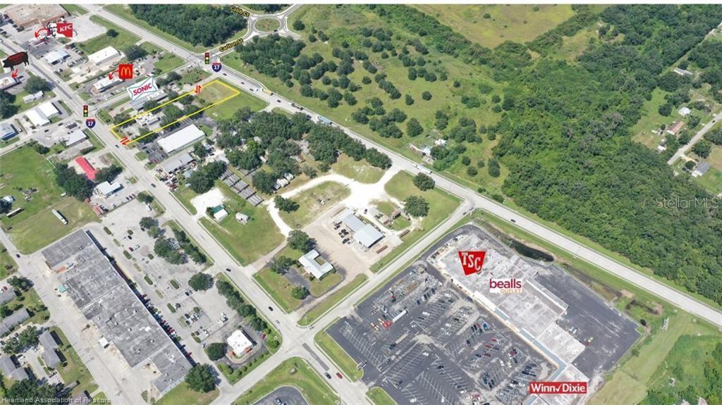 This aerial view shows a commercial area with retail stores, parking lots, and roads — 939 S 6TH AVENUE, WAUCHULA, FL