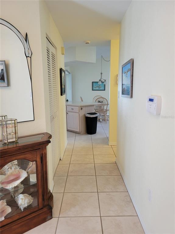 A tiled hallway leads to a kitchen with a breakfast bar and dining area — 9400 NEW MARTINSVILLE AVENUE, ENGLEWOOD, FL