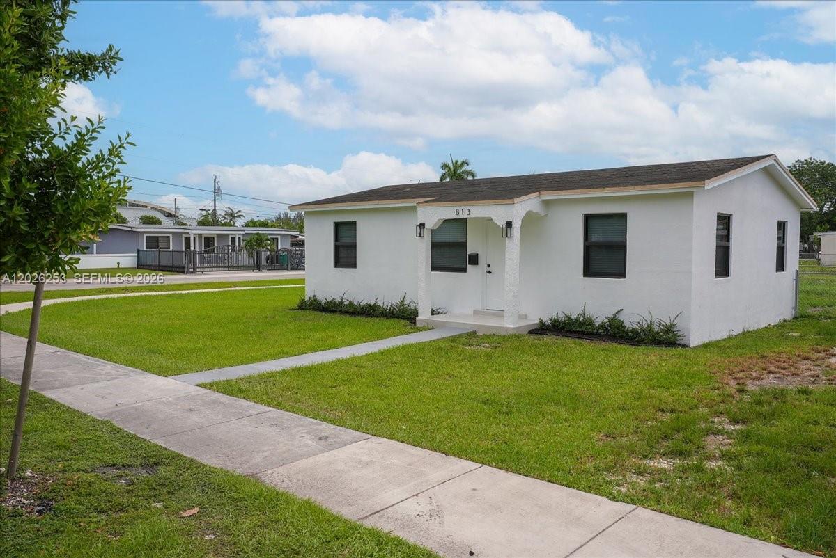 A white, single-story house with a small front porch sits on a grassy lot — 813 NW 6th Ave, Florida City FL 33034, FLORIDA CITY, FL