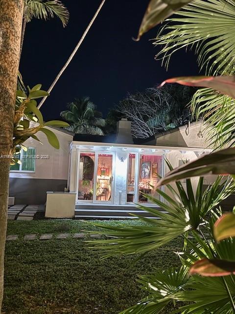 A one-story house with a white and gray exterior features a brick walkway and palm trees — 1643 Nethia Dr, Miami FL 33133, MIAMI, FL