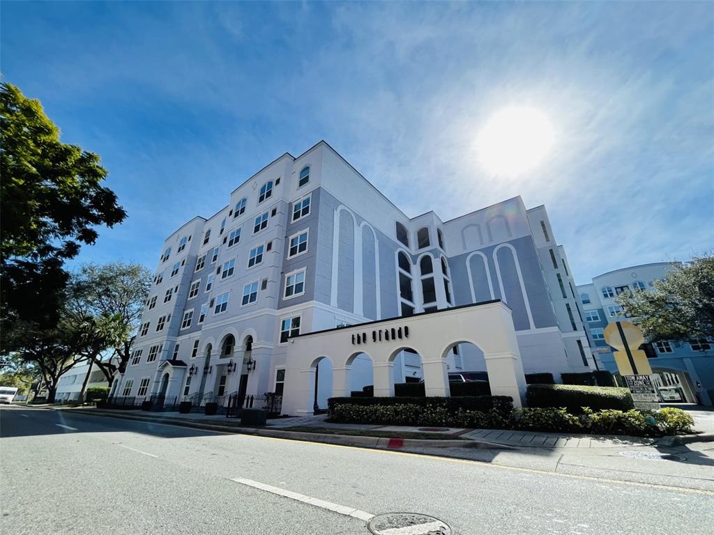 A low-angle exterior view of a multi-story apartment building named The Grande — 204 E SOUTH STREET UNIT 3059, ORLANDO, FL