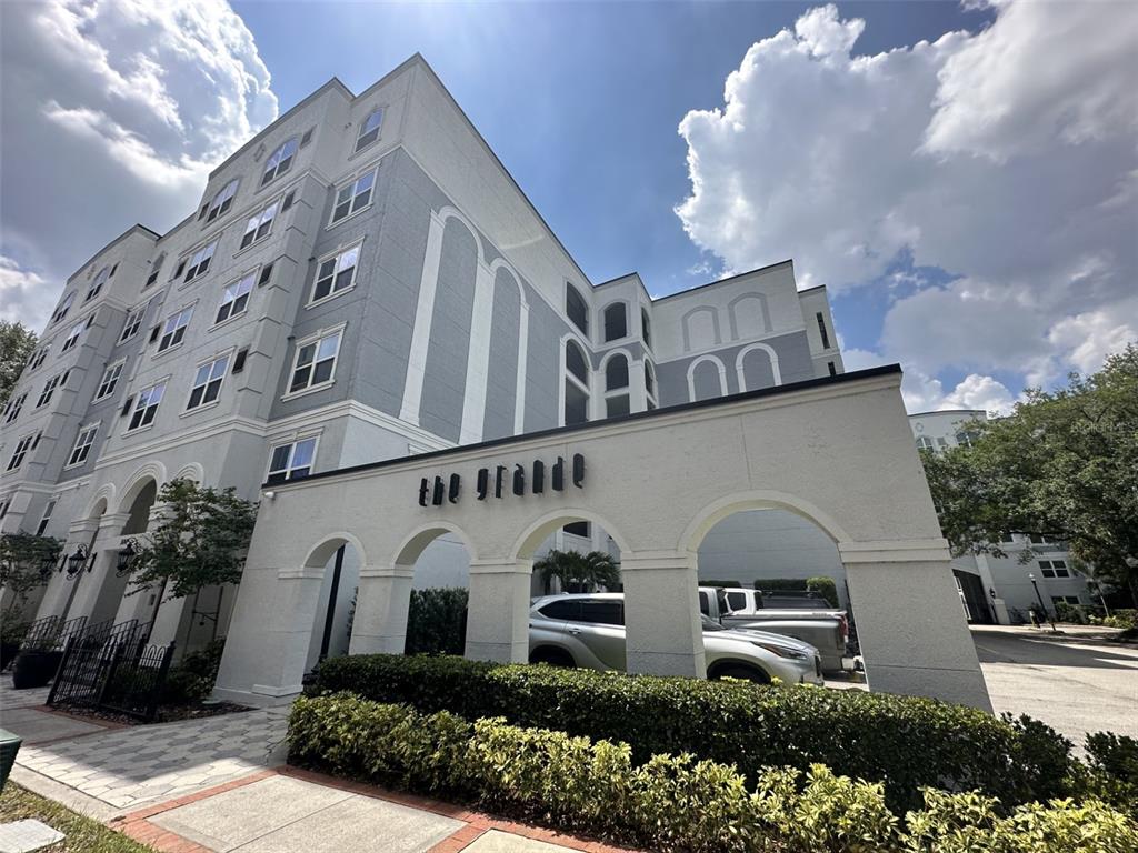 An exterior view of a multi-story apartment building with a decorative arched entrance structure — 204 E SOUTH STREET UNIT 3059, ORLANDO, FL