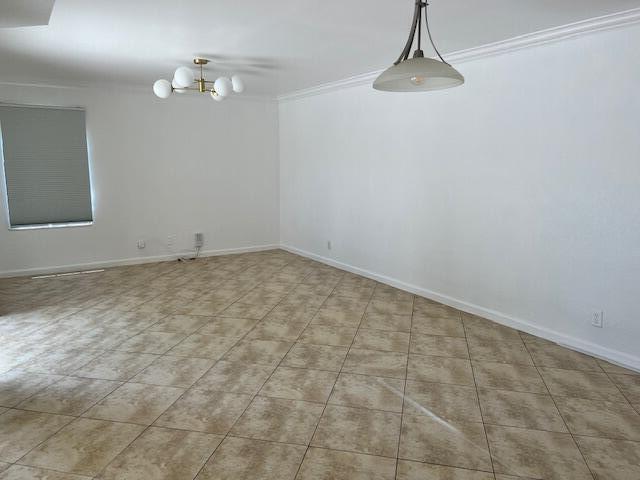 An empty room features beige tile flooring, white walls, and two hanging light fixtures — 8189 Thames Boulevard # D, Boca Raton FL 33433, BOCA RATON, FL