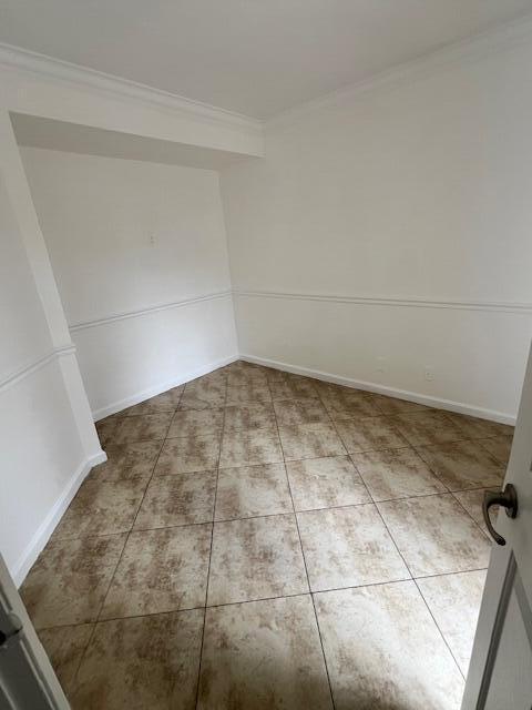 An empty room features beige tiled flooring and white walls with chair rail molding — 8189 Thames Boulevard # D, Boca Raton FL 33433, BOCA RATON, FL