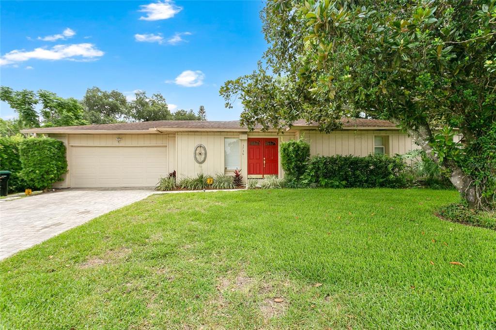 A single-story house with beige siding, a red double front door, and a paved driveway — 3736 LAKE MARGARET DRIVE, ORLANDO, FL