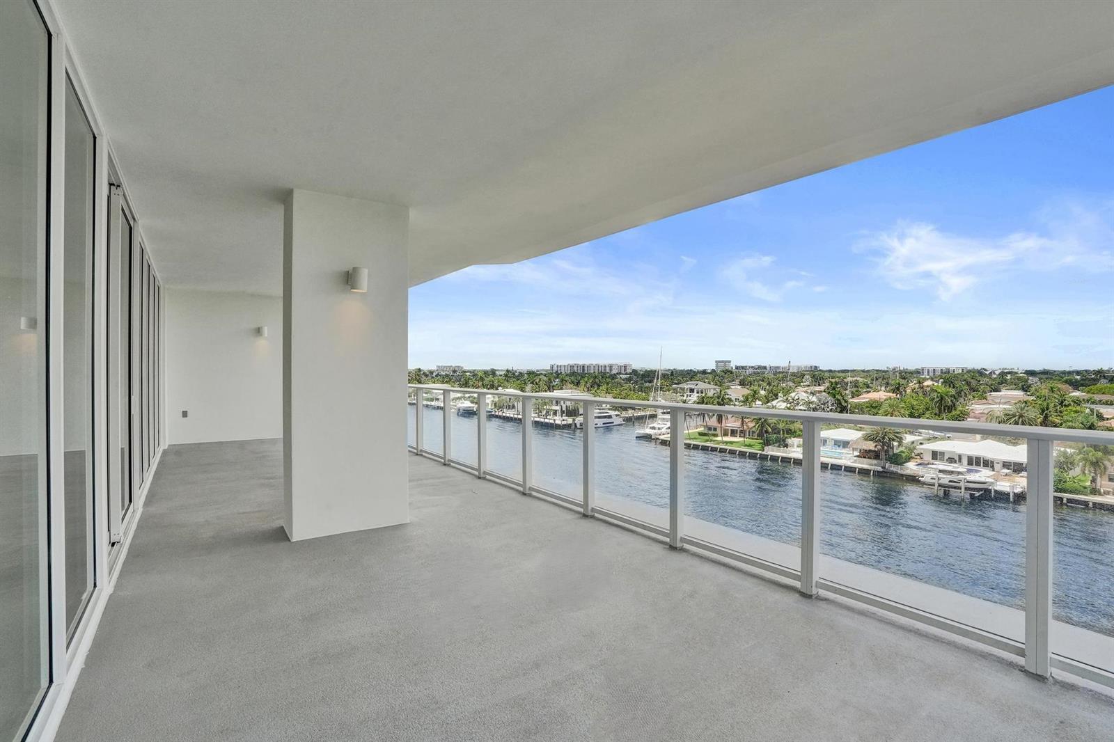 A spacious, covered concrete balcony overlooks a canal with boats and waterfront homes — 407 N Riverside Drive # 605, Pompano Beach FL 33062, POMPANO BEACH, FL