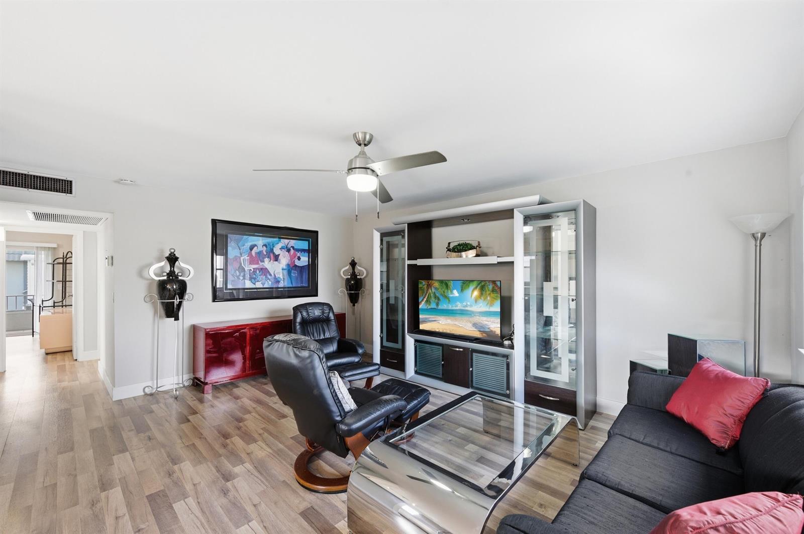 A living room features a glass coffee table, black leather recliners, and a media console — 756 Flanders P, Delray Beach FL 33484, DELRAY BEACH, FL