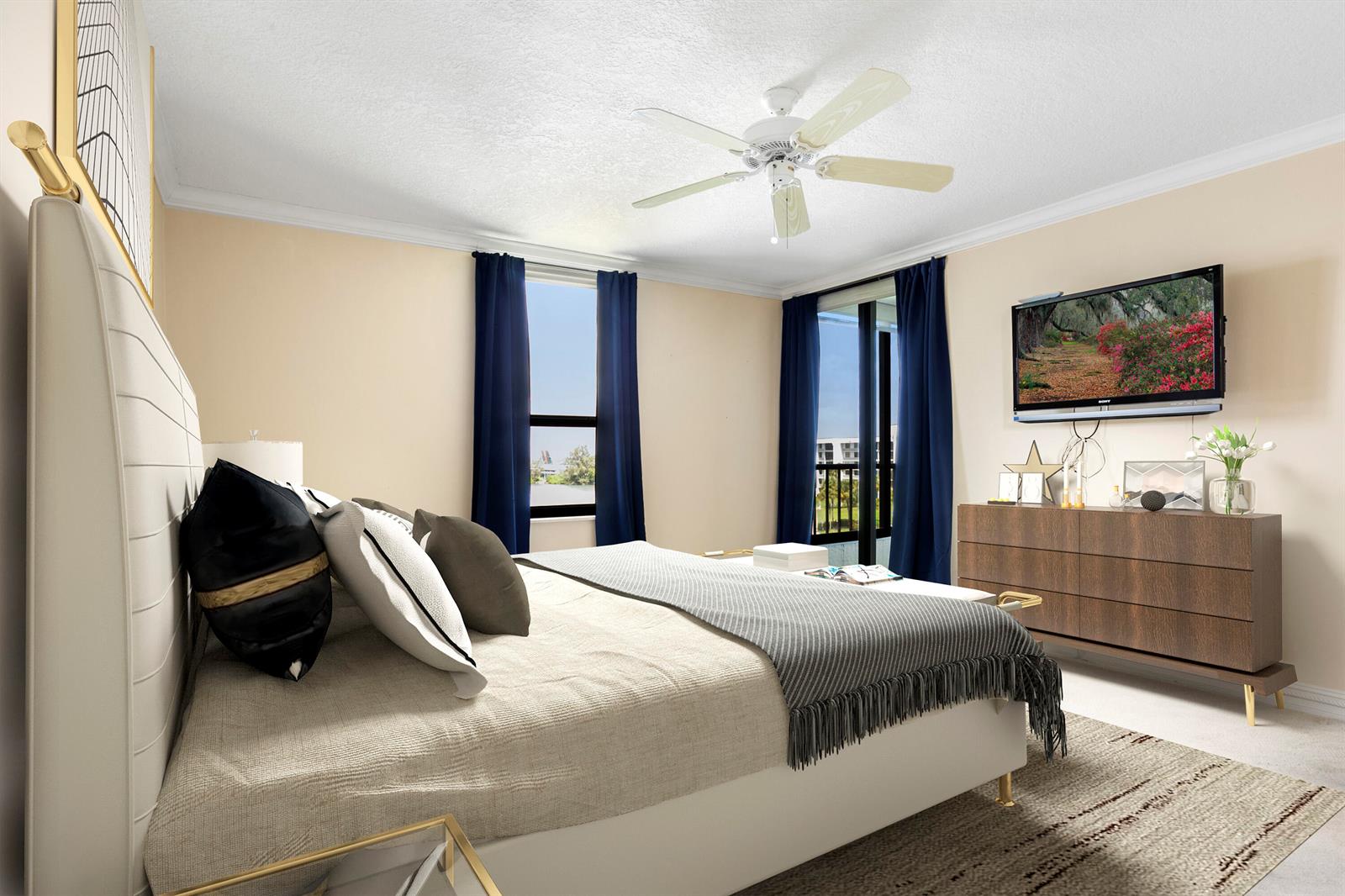 A bedroom features a bed, a dresser with a wall-mounted television, and blue curtains — 1748 Jupiter Cove Drive # 524a, Jupiter FL 33469, JUPITER, FL