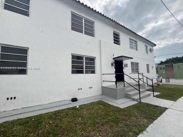 The exterior of a two-story white apartment building features a central entrance with stairs — 541 SW 7th St # 3, Miami FL 33130, MIAMI, FL