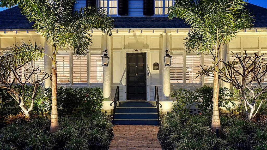 A brick walkway leads to the front entrance of a house with two palm trees — 7715 WESTMORELAND DRIVE, SARASOTA, FL