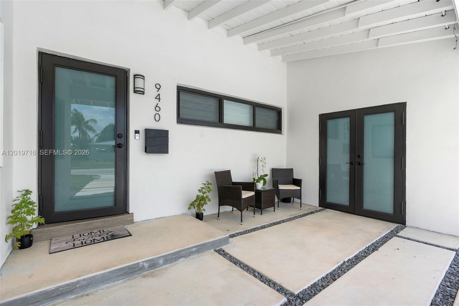 A covered entryway features a front door, double doors, two chairs, and concrete pavers — 9460 Haitian Dr, Cutler Bay FL 33189, CUTLER BAY, FL