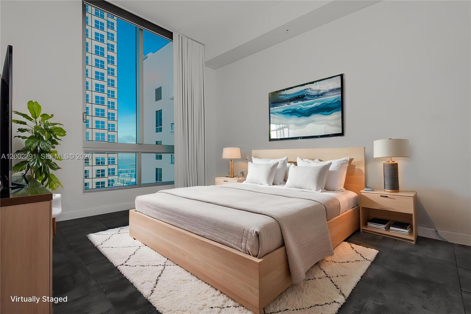 A modern bedroom features a light wood bed, white bedding, and a large window view — 300 S Biscayne Blvd # 3903, Miami FL 33131, MIAMI, FL