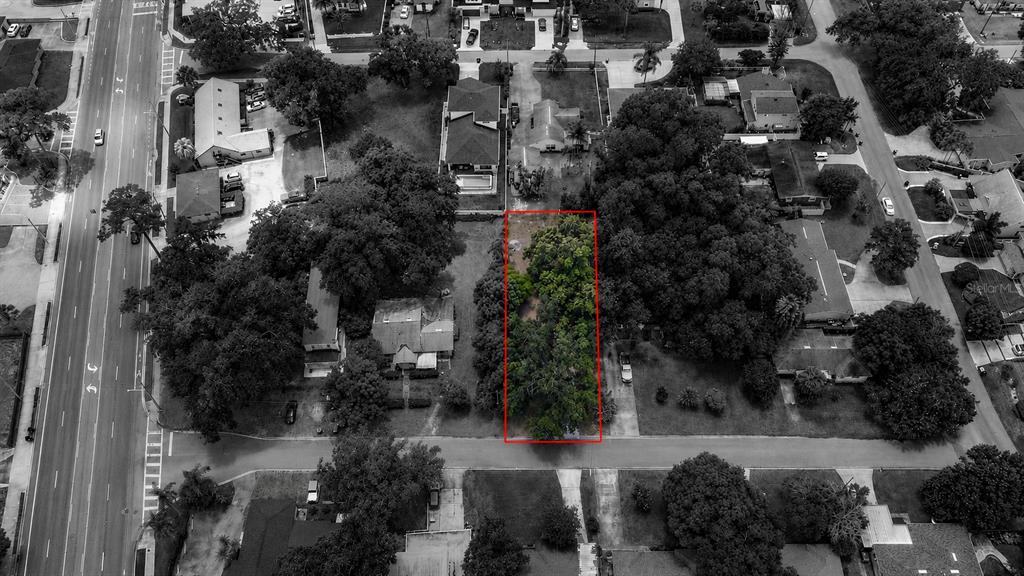 An aerial view shows a rectangular, tree-covered vacant lot outlined in red within a neighborhood — 1014 MEADOWS AVENUE, ORLANDO, FL