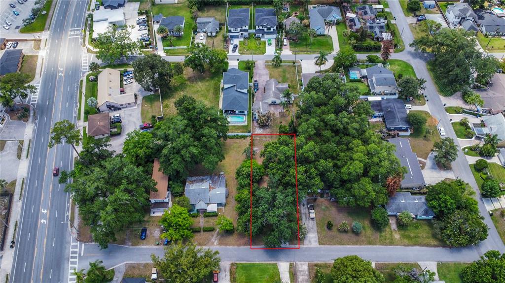 An aerial view shows a rectangular vacant lot outlined in red within a residential neighborhood — 1014 MEADOWS AVENUE, ORLANDO, FL